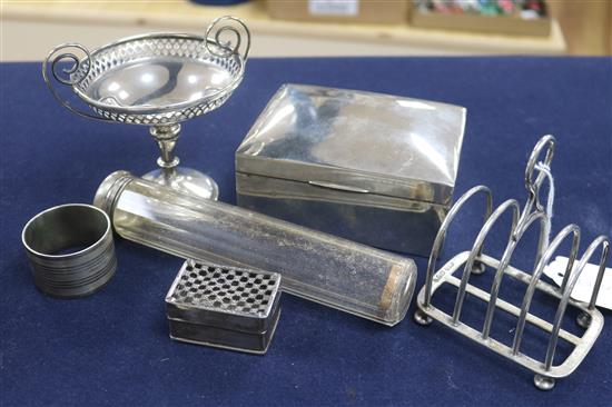 A silver five bar toastrack, a silver cigarette box, as silver pedestal nut dish and three other items including a napkin ring.